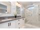 Modern bathroom with dual sinks, stylish mirrors, and a glass-enclosed shower with marble tiles at 1910 W Desert Hollow Dr, Phoenix, AZ 85085