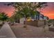 Modern home's backyard view featuring lush landscaping, contemporary design, and warm exterior lighting at 1910 W Desert Hollow Dr, Phoenix, AZ 85085