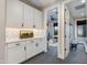 Hallway featuring white cabinets, subway tile backsplash, and an open doorway to a sunlit living room at 1910 W Desert Hollow Dr, Phoenix, AZ 85085