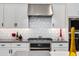 Close-up of a modern kitchen with stainless steel appliances, white cabinets, and stylish backsplash details at 1910 W Desert Hollow Dr, Phoenix, AZ 85085