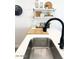 Modern kitchen sink with sleek fixtures and bright countertop space with decorative shelving at 20 S Buena Vista Ave # 111, Gilbert, AZ 85296