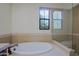 Bathroom features a soaking tub, a separate glass-enclosed shower, and a bright window view at 20750 N 87Th St # 2115, Scottsdale, AZ 85255
