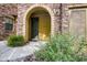Inviting front entrance with a stone archway, landscaped garden, and warm, welcoming ambiance at 20750 N 87Th St # 2115, Scottsdale, AZ 85255