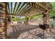 Outdoor grilling area featuring stone pillars, wooden pergola, and desert landscaping at 20750 N 87Th St # 2115, Scottsdale, AZ 85255