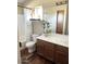 Well-lit bathroom with a wood vanity, white countertop, and a shower with white and gray tile at 2150 E Bell Rd # 1068, Phoenix, AZ 85022