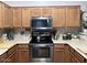 The well-lit kitchen features stainless steel appliances, wooden cabinets, and light granite countertops at 2150 E Bell Rd # 1068, Phoenix, AZ 85022