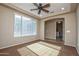 Bright bedroom featuring a large window and ceiling fan, with an adjacent laundry room at 21883 N 263Rd Dr, Buckeye, AZ 85396