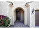 Covered front entrance showcasing a charming archway and manicured landscaping, creating a welcoming ambiance at 21883 N 263Rd Dr, Buckeye, AZ 85396