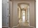 View of hallway leading to an airy living room, complete with tile floors and white doors at 21883 N 263Rd Dr, Buckeye, AZ 85396