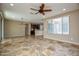Spacious open-concept living room, with tile flooring, a ceiling fan and view of the kitchen at 21883 N 263Rd Dr, Buckeye, AZ 85396