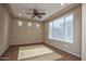 Bright living room features three small windows, plus a large window for ample sunlight and a ceiling fan at 21883 N 263Rd Dr, Buckeye, AZ 85396