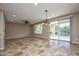 Bright, open living room with tile flooring, ceiling fan, and sliding glass doors to outdoor space at 21883 N 263Rd Dr, Buckeye, AZ 85396