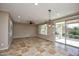 Bright living room with tile floors, ceiling fan, and sliding glass doors to the outside patio at 21883 N 263Rd Dr, Buckeye, AZ 85396
