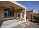 Cozy covered patio with outdoor fireplace, ceiling fan, and adjacent barbecue area at 21883 N 263Rd Dr, Buckeye, AZ 85396