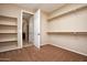 Empty walk-in closet featuring neutral paint, carpet, and hanging racks with built-in shelving at 21883 N 263Rd Dr, Buckeye, AZ 85396