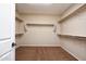 Empty walk-in closet featuring neutral paint, carpet, and hanging racks around the perimeter of the space at 21883 N 263Rd Dr, Buckeye, AZ 85396