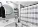 Stylish bathroom featuring a round mirror, floating shelves, and a decorative shower curtain at 2201 N Comanche Dr # 1093, Chandler, AZ 85224