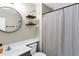 Modern bathroom features a round mirror, floating shelves, and a striped shower curtain, creating a stylish space at 2201 N Comanche Dr # 1093, Chandler, AZ 85224