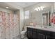 Bright bathroom featuring double sinks, dark cabinets, a floral shower curtain, and ample counter space at 22136 N 28Th Pl, Phoenix, AZ 85050