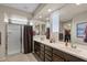 Bright bathroom featuring double sinks, dark cabinets, a walk-in shower, and ample counter space at 22136 N 28Th Pl, Phoenix, AZ 85050