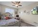 A bedroom featuring neutral walls, a plush bed, a desk, and a well-lit window view at 22136 N 28Th Pl, Phoenix, AZ 85050
