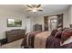 Spacious bedroom with a TV, ceiling fan, dresser, barn door and comfortable furnishings at 22136 N 28Th Pl, Phoenix, AZ 85050