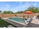 Beautiful backyard pool with stylish brick pavers, lounge chairs, and orange umbrella providing a relaxing outdoor space at 22136 N 28Th Pl, Phoenix, AZ 85050