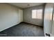 This bedroom offers plush carpeting and a light-filled space with a window and neutral wall color at 22311 W Woodlands Ave, Buckeye, AZ 85326