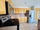Kitchen featuring stainless steel appliances, light wood cabinets, and tiled flooring, providing a modern and functional space at 22311 W Woodlands Ave, Buckeye, AZ 85326