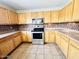 Kitchen with stainless steel oven and microwave with light wood cabinets and a tiled backsplash at 22311 W Woodlands Ave, Buckeye, AZ 85326
