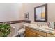 Powder room with a framed mirror, tiled vanity, floral wallpaper and a plant at 23760 N 80Th Way, Scottsdale, AZ 85255