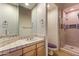 Bathroom featuring a tiled vanity, large mirror, toilet and glass enclosed tiled shower at 23760 N 80Th Way, Scottsdale, AZ 85255