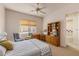 Bright bedroom featuring a ceiling fan, sitting area, and built-in desk with drawers and storage at 23760 N 80Th Way, Scottsdale, AZ 85255