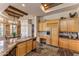 Open-concept kitchen and dining area with stone floors, custom wood cabinetry, and modern stainless steel appliances at 23760 N 80Th Way, Scottsdale, AZ 85255