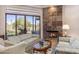 Cozy living room featuring a stone fireplace, large windows, and comfortable seating at 23760 N 80Th Way, Scottsdale, AZ 85255