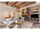 Living room boasts wood beam ceilings, stone fireplace, built-in shelving and a large window at 23760 N 80Th Way, Scottsdale, AZ 85255