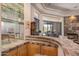 Stylish wet bar adjacent to living room with mirror backsplash and tile countertop at 23760 N 80Th Way, Scottsdale, AZ 85255