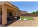 Spacious backyard with a covered patio, artificial grass area, and low-maintenance landscaping at 27420 N 63Rd Dr, Phoenix, AZ 85083