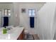 Clean bathroom boasts a modern vanity, tile flooring, and shower with a white curtain at 27420 N 63Rd Dr, Phoenix, AZ 85083