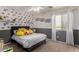 Well-lit bedroom featuring fun wallpaper, a comfortable bed, and a large window at 27420 N 63Rd Dr, Phoenix, AZ 85083