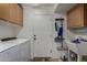Functional laundry room equipped with a washer, dryer, storage cabinets, and utility sink at 27420 N 63Rd Dr, Phoenix, AZ 85083