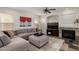 Comfortable living room featuring a cozy gray sectional couch, fireplace and a ceiling fan at 27420 N 63Rd Dr, Phoenix, AZ 85083