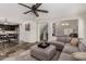 Comfortable living room featuring a cozy gray sectional couch and open floor plan to the kitchen at 27420 N 63Rd Dr, Phoenix, AZ 85083