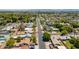 An aerial view of a tree-lined suburban street with single-Gathering homes, landscaping, and city buildings in the background at 3115 N 26Th St, Phoenix, AZ 85016