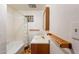 Bathroom with tub, tile surround, a vanity and wood shelves at 3115 N 26Th St, Phoenix, AZ 85016