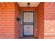 Close-up of the red-brick entrance featuring a secure screen door and vintage light fixture at 3115 N 26Th St, Phoenix, AZ 85016
