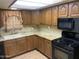 Functional kitchen featuring wood cabinets, granite countertops, a double sink, and modern black appliances at 3115 N 26Th St, Phoenix, AZ 85016