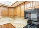 Kitchen features wooden cabinets, granite countertops, and modern black appliances at 3115 N 26Th St, Phoenix, AZ 85016