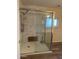 Updated shower with glass doors, marble-like tile, and a built-in bench for a spa-like experience at 3115 N 26Th St, Phoenix, AZ 85016