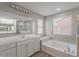 Bathroom showcasing a soaking tub, vanity with storage, and tile accents at 316 N 78Th Pl, Mesa, AZ 85207